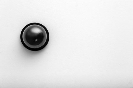 Modern CCTV security camera on white wall. Space for text