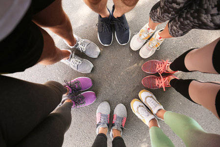 Young people making circle and showing their sports shoes outdoors, above viewの写真素材