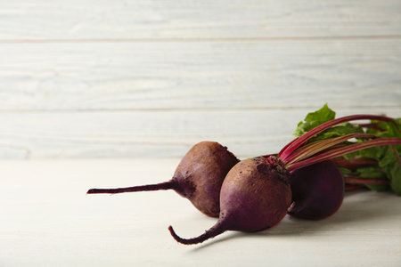 Fresh beets on wooden table against white background. Space for textの写真素材