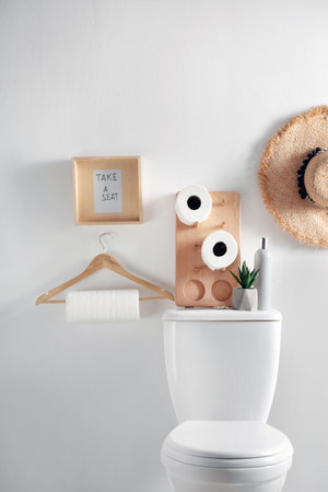 Decor elements, necessities and toilet bowl near white wall. bathroom interior