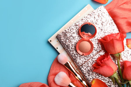 Flat lay composition with coral cosmetics and flowers on light blue background. Space for textの写真素材