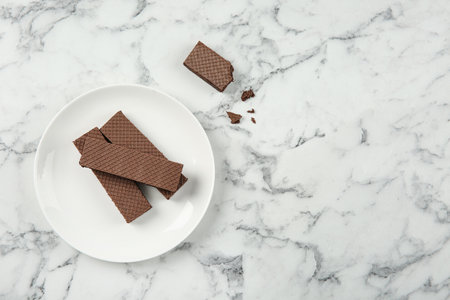 Plate of delicious chocolate wafers on marble background, top view. Space for textの写真素材