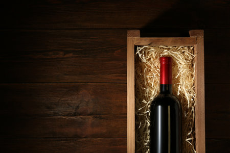 Crate with bottle of wine on wooden table, top view. Space for textの写真素材