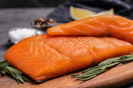 Wooden board with salmon fillet on gray table, closeupの写真素材