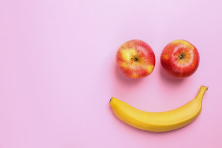 Tasty raw apples and banana on pink background, flat lay with space for textの写真素材