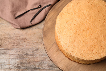 Delicious fresh homemade and napkin cake on wooden table, flat lay