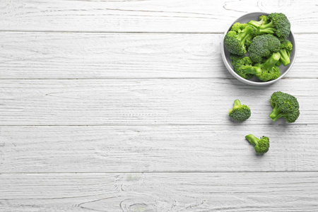 Flat lay composition of fresh green broccoli on white wooden table, space for textの写真素材