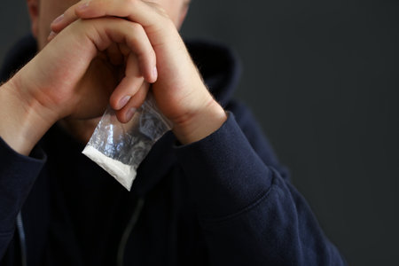 Criminal holding plastic bag with drug indoors, space for textの写真素材