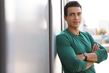 Handsome young African-American man near wall on city street. Space for textの写真素材