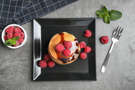 Tasty pancakes with raspberries served on grey table, flat layの写真素材
