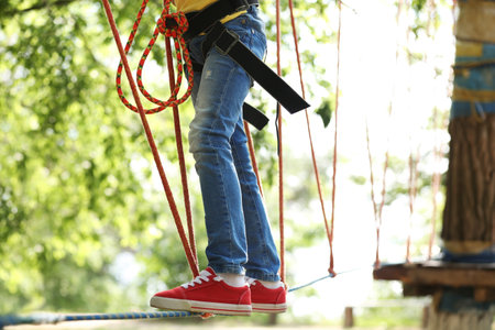 Little girl climbing in adventure park. Summer campの写真素材