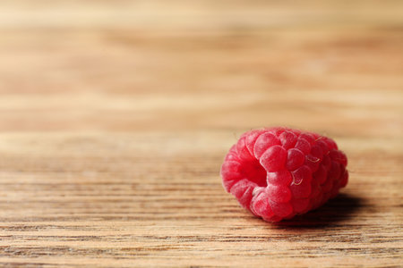 Delicious ripe raspberry on wooden table, closeup. Space for textの写真素材