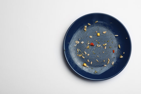 Dirty plate with food leftovers on white background, top viewの写真素材