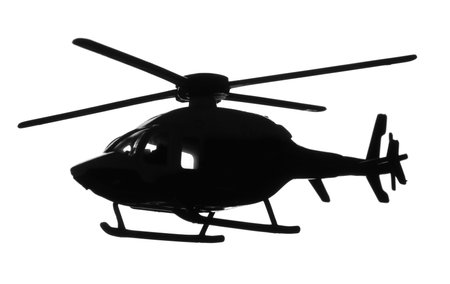 Dark silhouette of toy military helicopter on white backgroundの写真素材