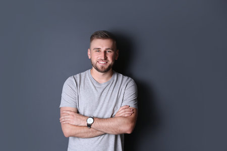 Portrait of handsome happy man on grey background
