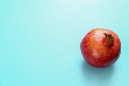 Tasty raw pomegranate on blue background, space for textの写真素材
