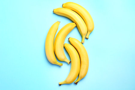 Ripe tasty bananas on blue background, flat layの写真素材