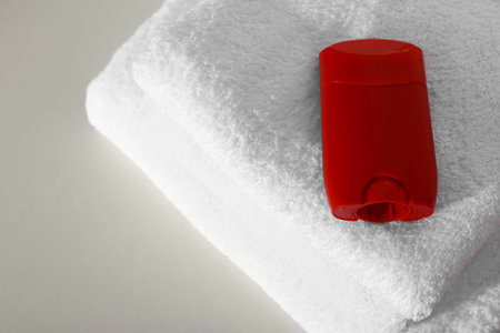 Deodorant with clean towels on light background, above view. Space for textの写真素材