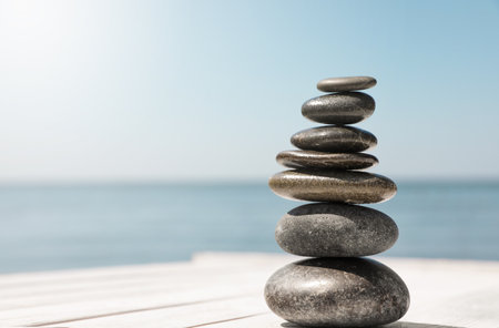 Stack of stones on wooden pier near sea, space for text. Zen conceptの写真素材