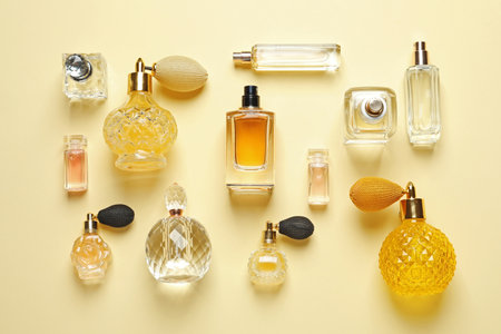 Flat lay composition with different perfume bottles on light yellow backgroundの写真素材