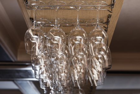 Set of empty clean glasses on bar racksの写真素材