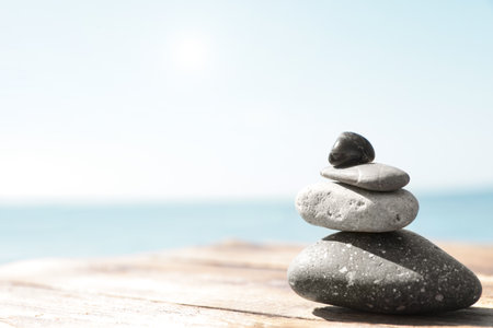 Stack of stones on wooden pier near sea, space for text. Zen conceptの写真素材