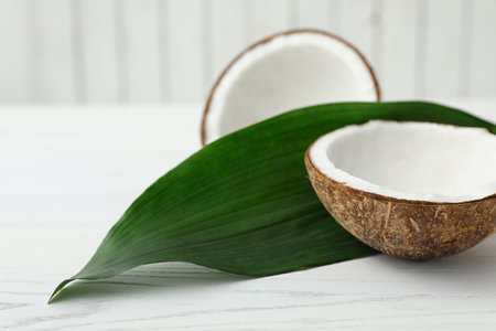Composition with halves of coconut on white wooden backgroundの写真素材