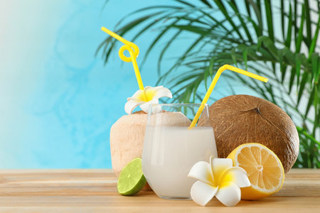 Composition with glass of coconut water on wooden table against blue background. Space for textの写真素材