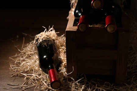 Composition with crate and bottles of wine on wooden tableの写真素材