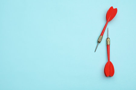 Red dart arrows on blue background, flat lay with space for textの写真素材