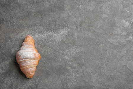 Tasty croissant with powdered sugar and space for text on gray background, top view. french pastryの写真素材