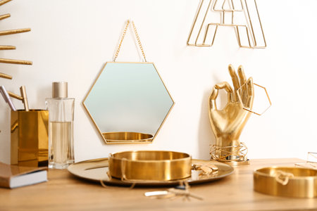 Composition with gold accessories on dressing table near white wallの写真素材