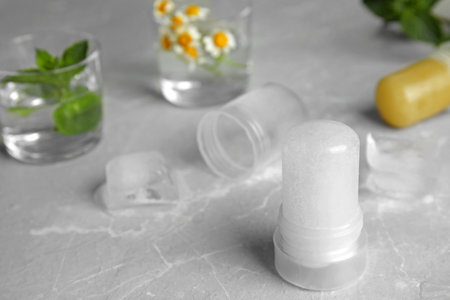 Natural crystal alum deodorant on light gray marble background