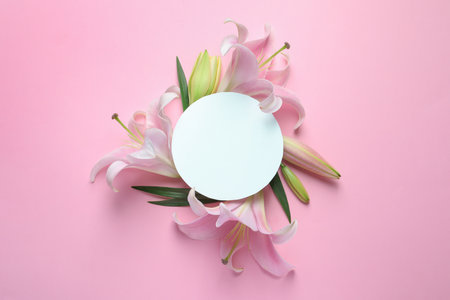 Blank card with fresh lily flowers on pink background, flat lay. Space for textの写真素材