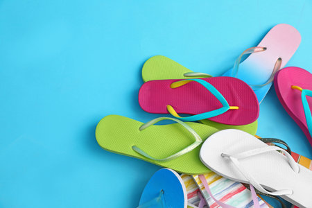 Heap of different flip flops and space for text on blue background, top view. summer beach accessoriesの写真素材