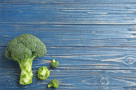 Fresh broccoli florets on blue wooden table, flat lay with space for textの写真素材