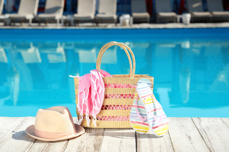 Beach accessories on wooden deck near outdoor swimming poolの写真素材