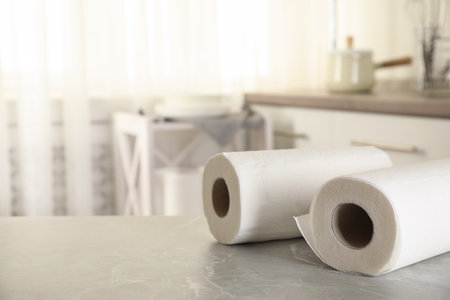 Rolls of paper towels on white marble table in kitchen, space for textの写真素材