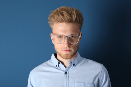 Portrait of handsome young man on blue backgroundの写真素材