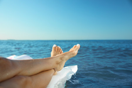 Beautiful young woman on inflatable mattress in sea, closeup. Space for text