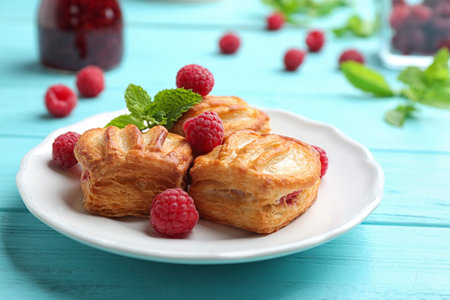 Fresh delicious puff pastry with sweet berries served on light blue wooden tableの写真素材