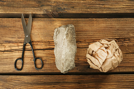 Flat lay composition with rock, paper and scissors on wooden backgroundの写真素材