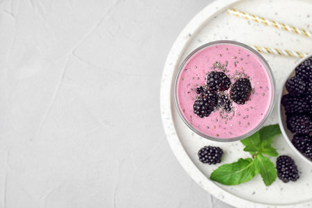 Delicious blackberry smoothie in glass served on light table, top view. Space for textの写真素材