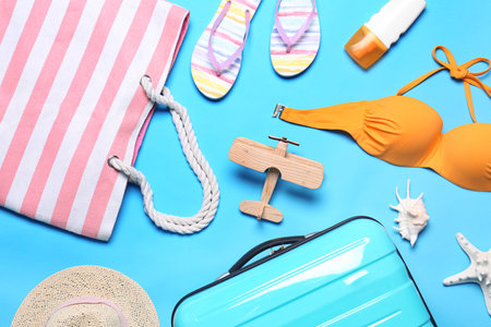 Flat lay composition with suitcase and beach objects on blue backgroundの写真素材