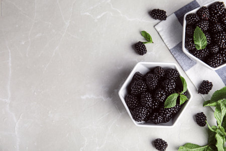 Flat lay composition with tasty blackberries and space for text on gray marble tableの写真素材