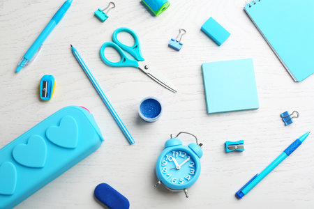 Different bright school stationery on white wooden background, flat layの写真素材