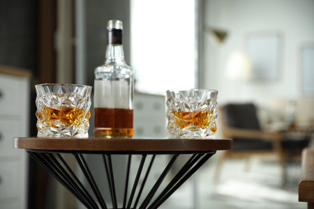 Glasses and bottles of whiskey on table indoorsの写真素材