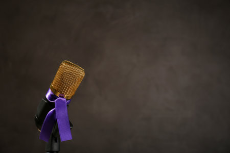 Microphone with purple awareness ribbon on dark background, space for textの写真素材