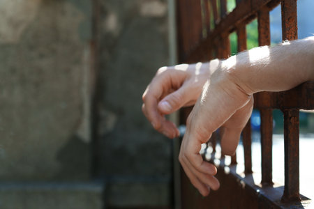 Man detained in jail outdoors, space for text. criminal lawの写真素材