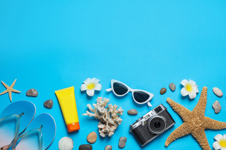 Flat lay composition with stylish beach accessories on light blue background, space for textの写真素材